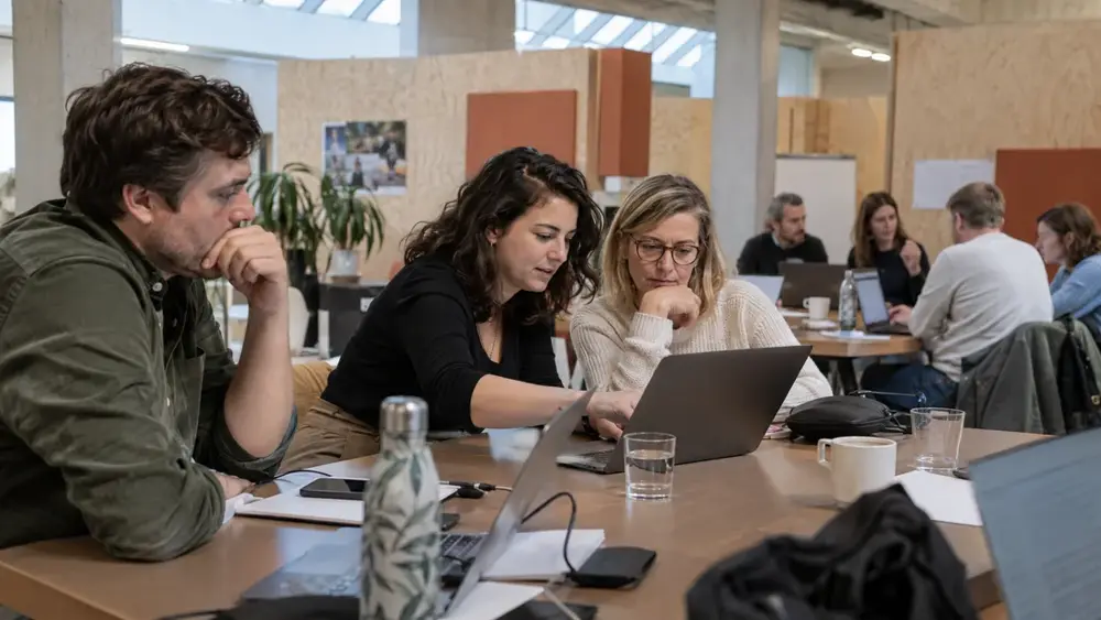 Collega’s werken samen aan een bureau